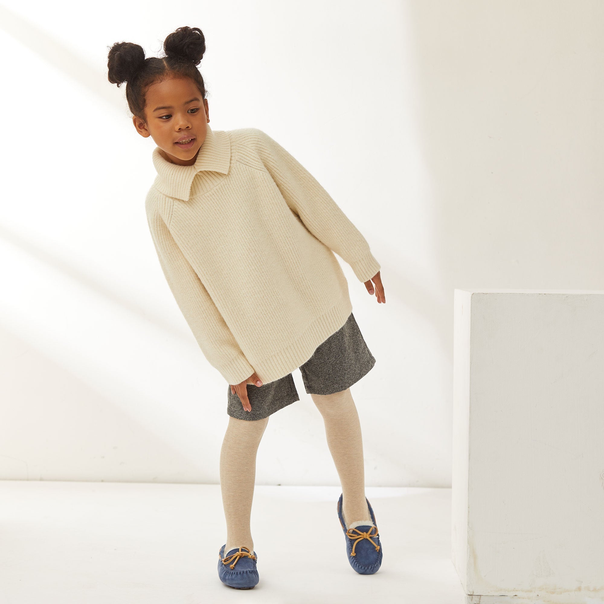 a girl toddler fashionable while wearing knitted tops and UGG Mocassins