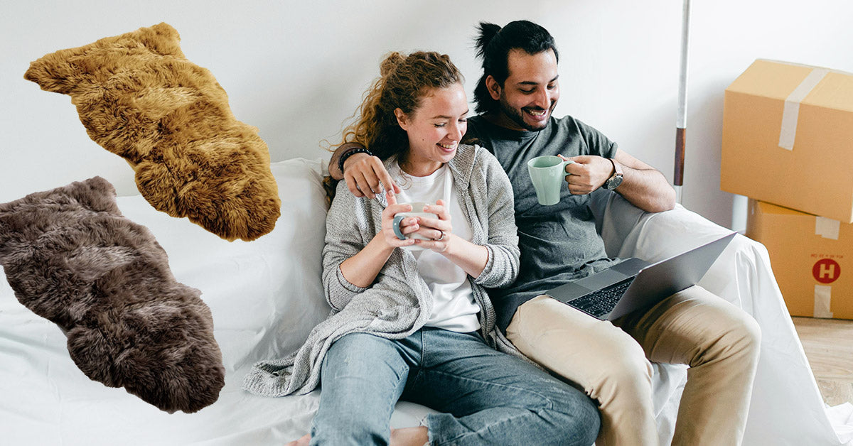 Happy couple relaxing on a couch with a cosy sheepskin rug, a thoughtful housewarming gift