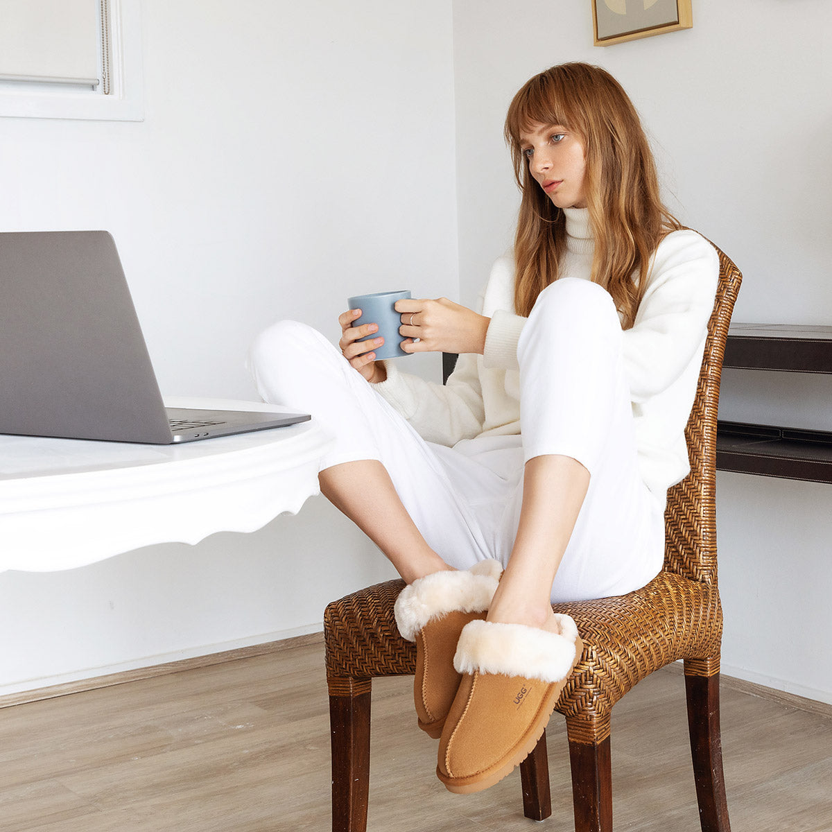 a woman wearing UGG slippers while working at home